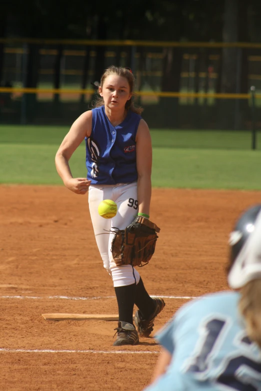 a  throws a softball from the mound