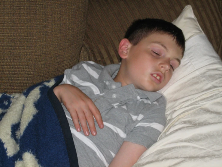 a child sleeping on top of a blue blanket