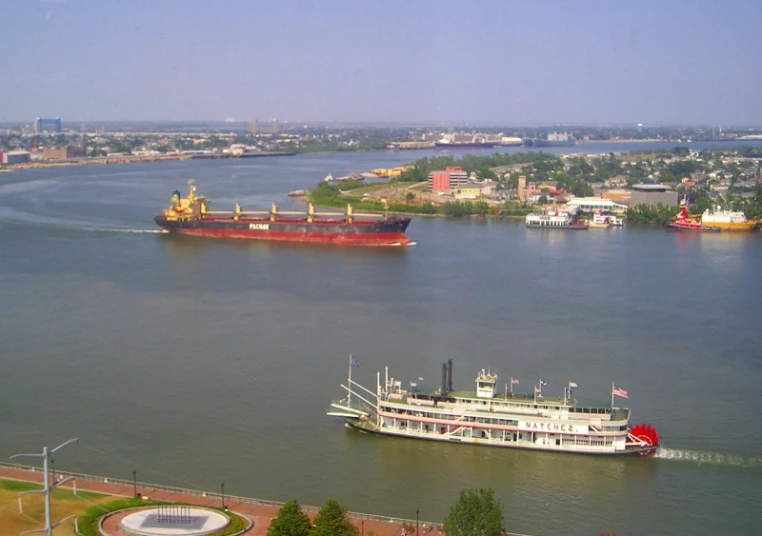 a boat in a river passing by a barge