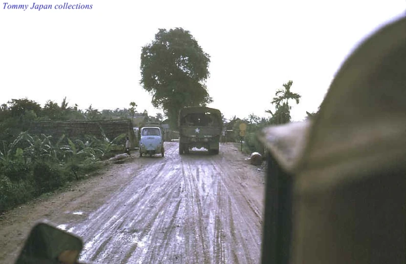 a truck going down a road between two vehicles