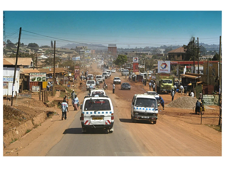 a busy dirt road lined with lots of people