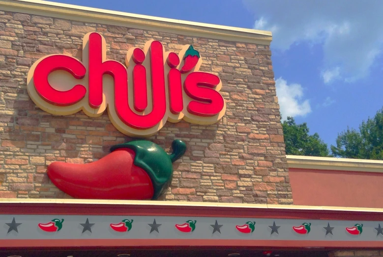 a colorful, bright sign in front of a large restaurant