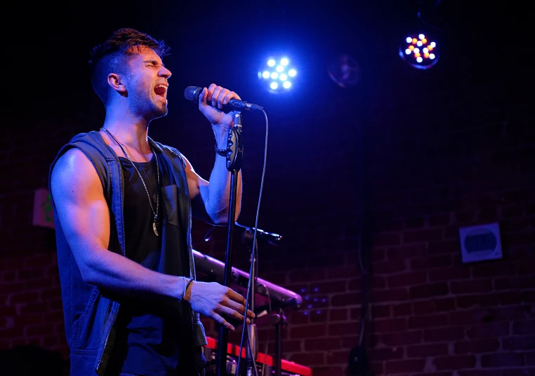 a man on stage singing with a microphone