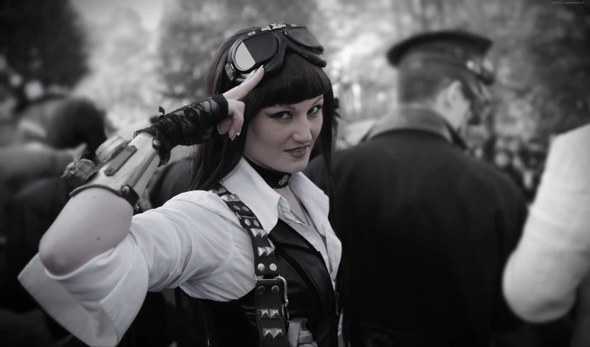 a woman in black leathers holding a gun to her head