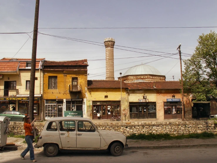 a car parked on the side of a road near buildings