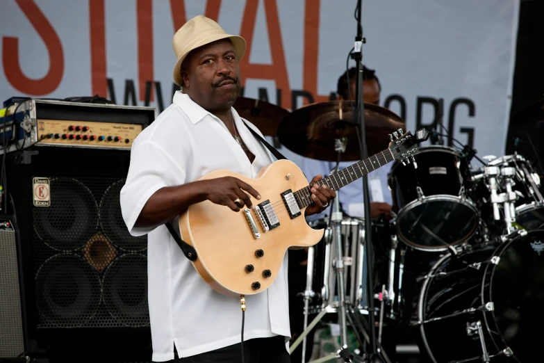 a man playing guitar in front of two bass drums