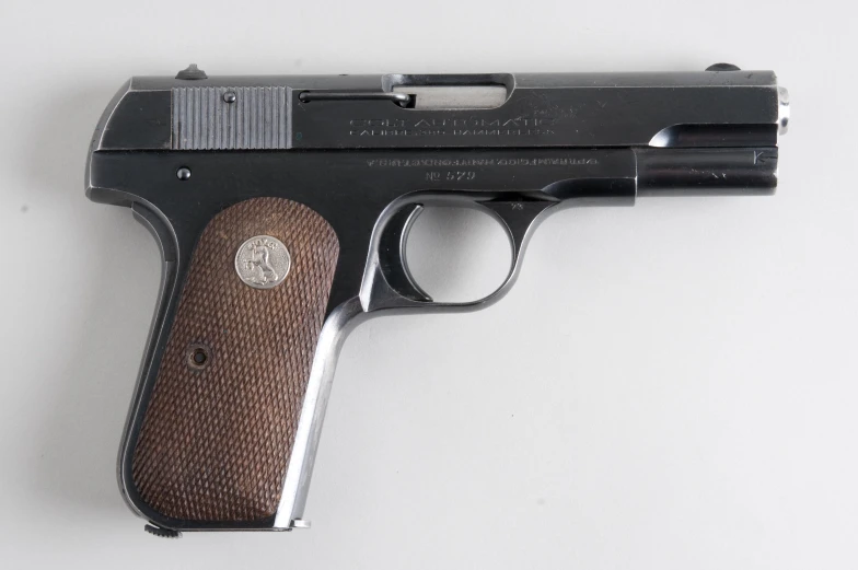 a black and brown gun is sitting on a white table