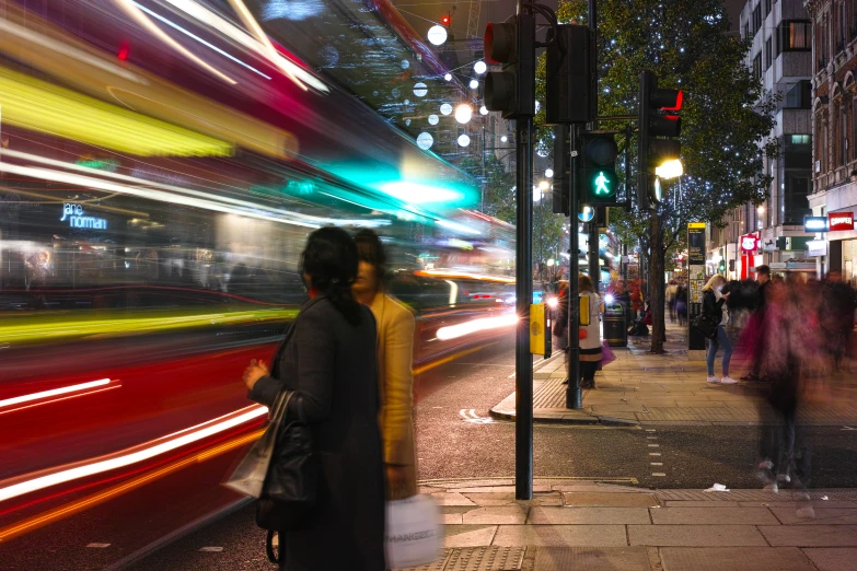 a woman is walking down the sidewalk near a bus