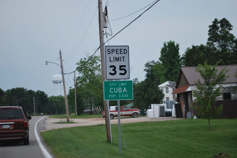 a speed limit sign and the other cars are driving on the road