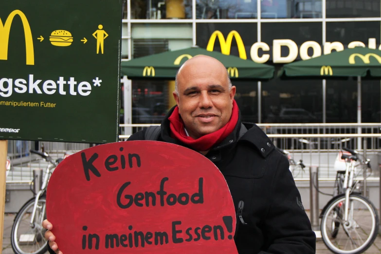 a man in a black jacket holding a sign