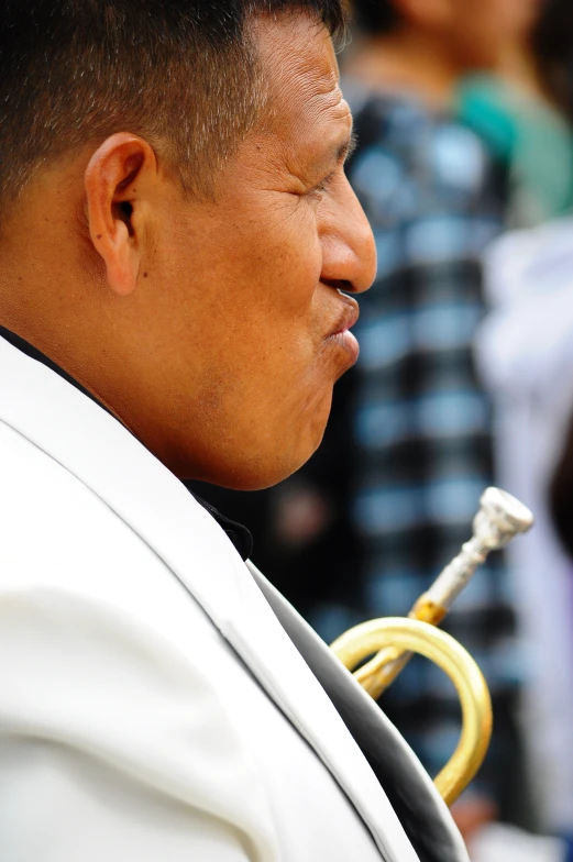a man in white shirt holding an instrument to his ear