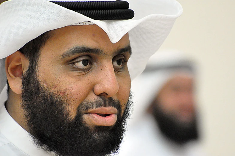 an abuour man with a beard and a dark brown dress