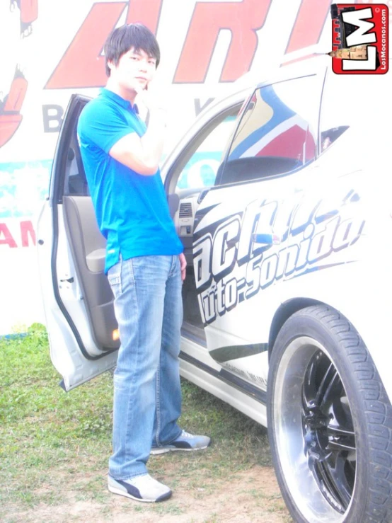 a man standing next to the back door of a car