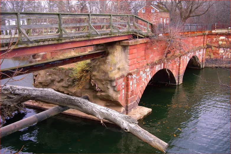 the bridge is red in color next to the river