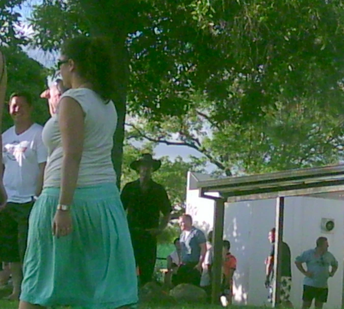 a young woman is walking in a park next to a man in a red jacket