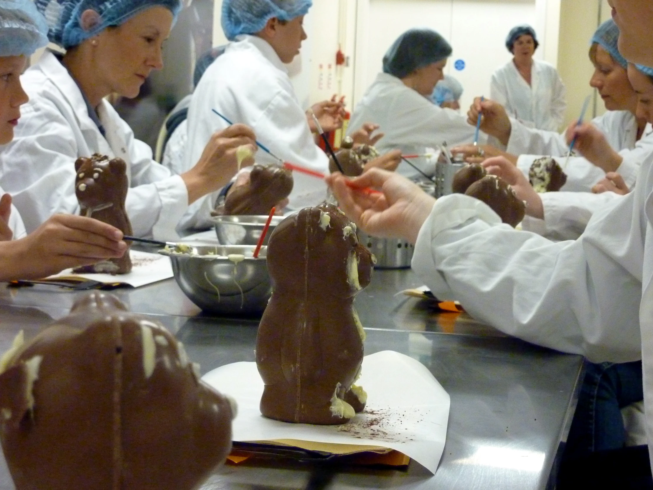 a group of people wearing chefs hats make chocolate animal sculptures