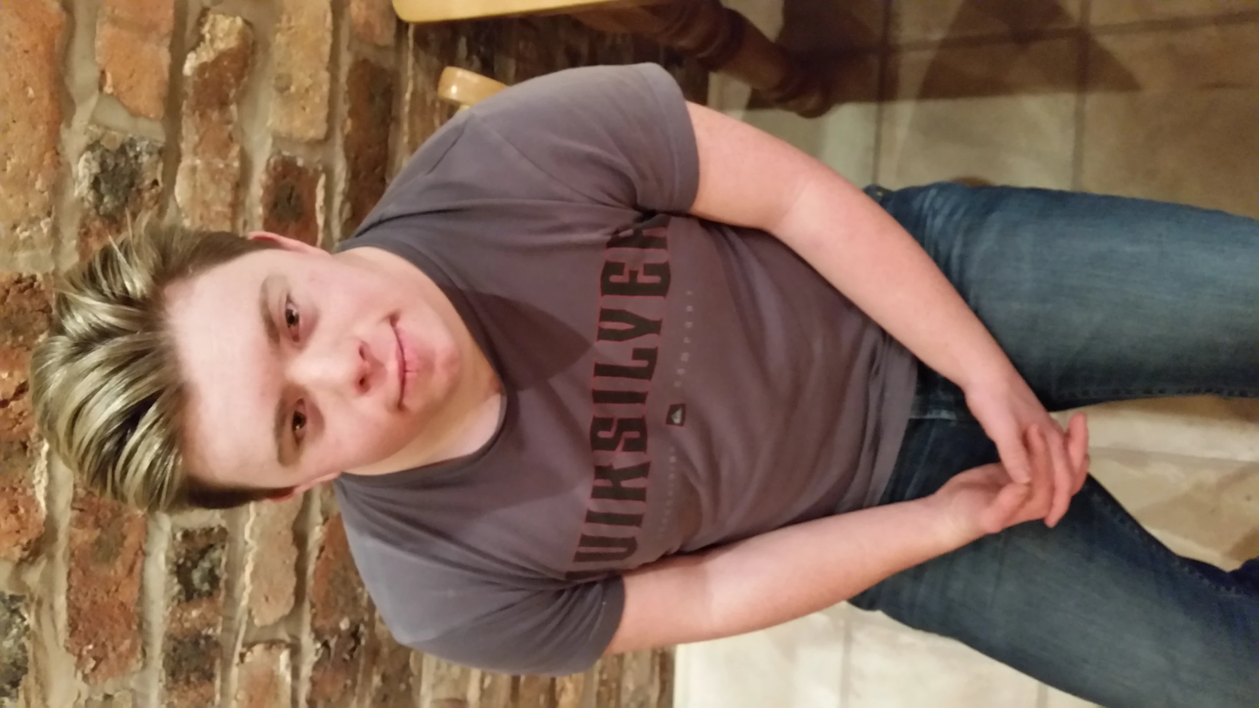 young man wearing an unissiliged shirt sitting on a chair