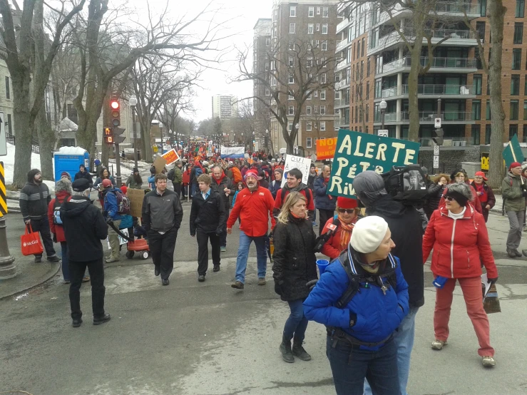 a large crowd of people are marching on a street