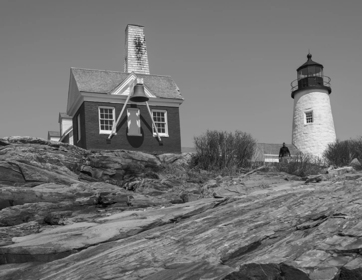 a lighthouse on a rock on top of a hill