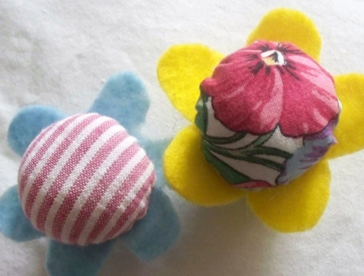two small stuffed flowers and one red one yellow