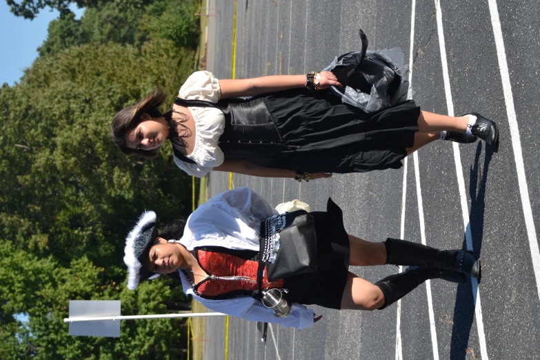 two people dressed in black and white walking down the street