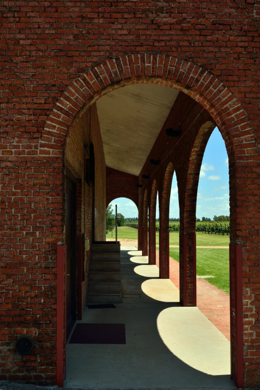 several arches with steps beneath them along a brick walkway