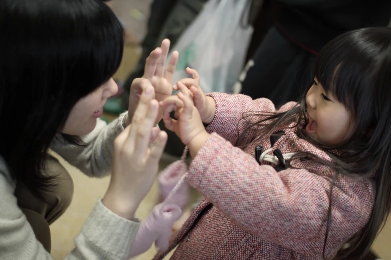 two asian women are showing a young child what to do