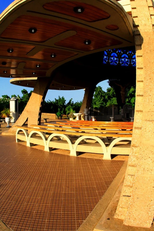 some benches and tables near the ground under a structure