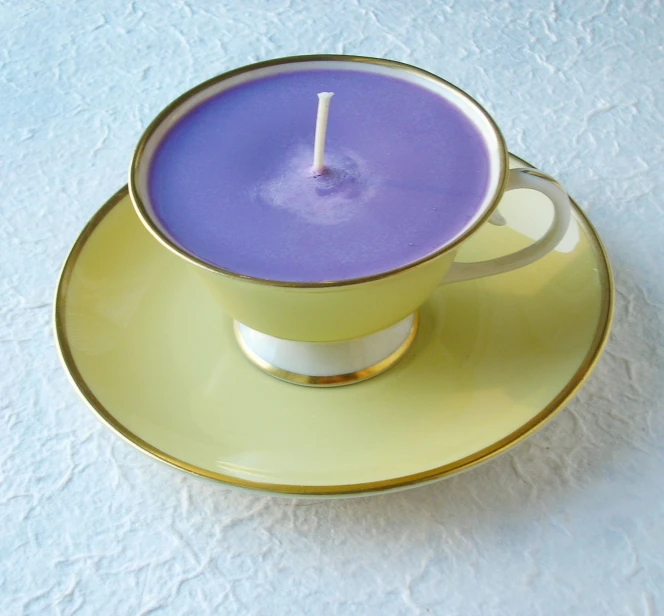 a yellow saucer sitting next to a purple candle