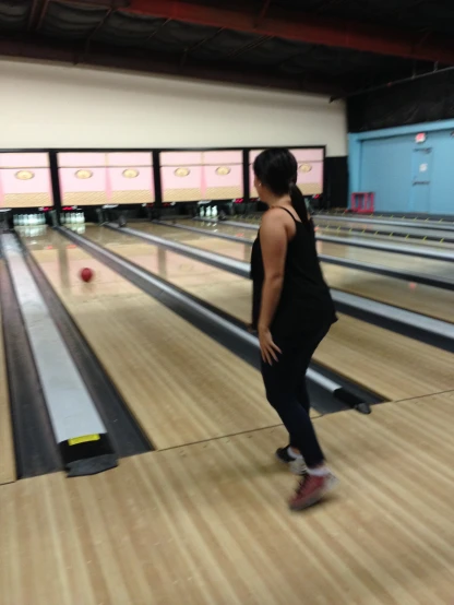 the woman is going down the bowling alley
