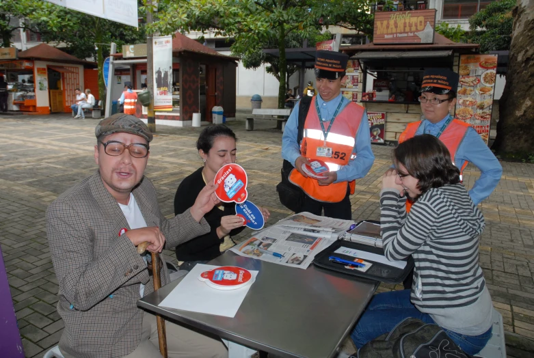 several people wearing orange vests sitting at a table together