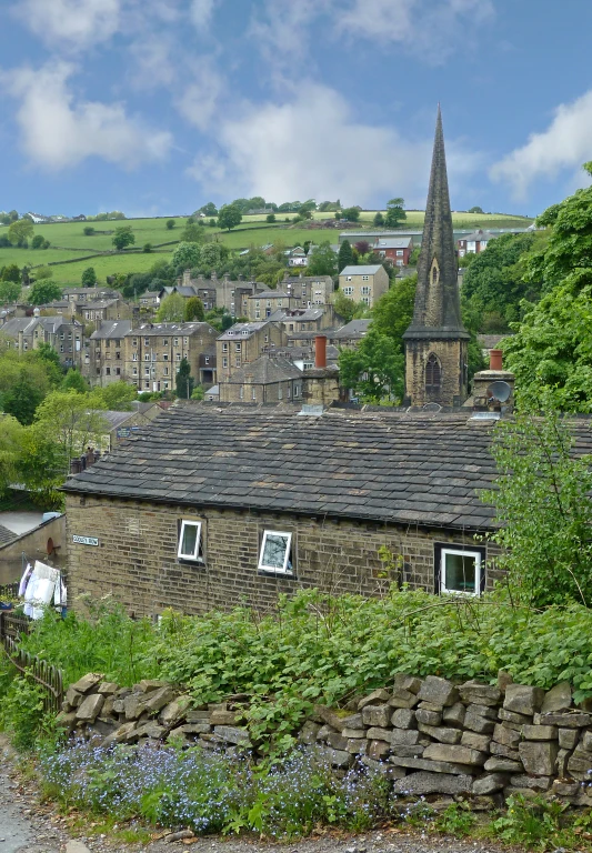 a stone building with a steeple above it is on a rural road