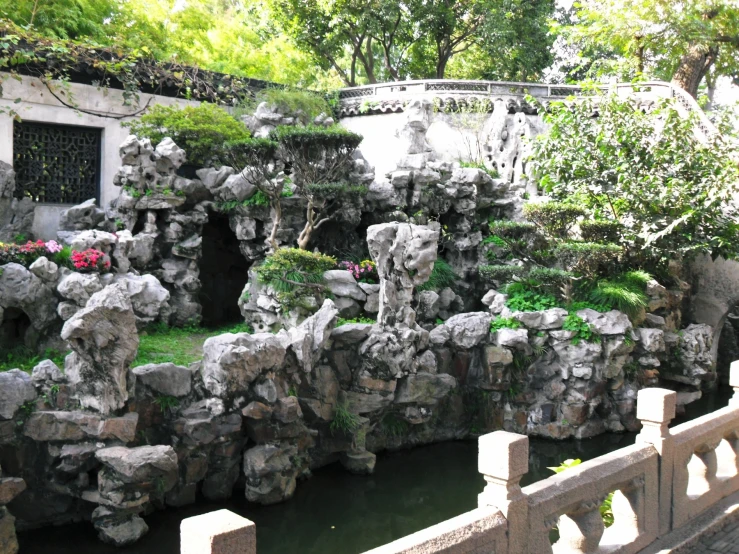 stone rock waterfall with pink flowers in center