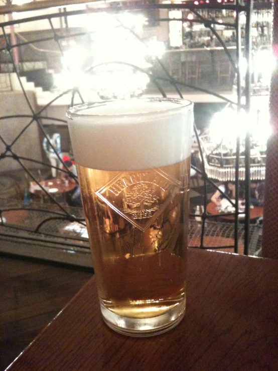 a beer in a tall glass on a wooden table