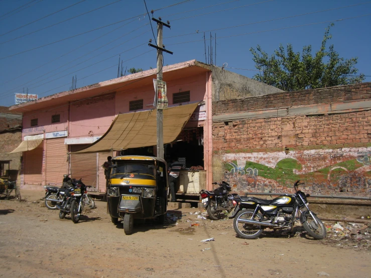 a motorcycle is parked outside of a pink building