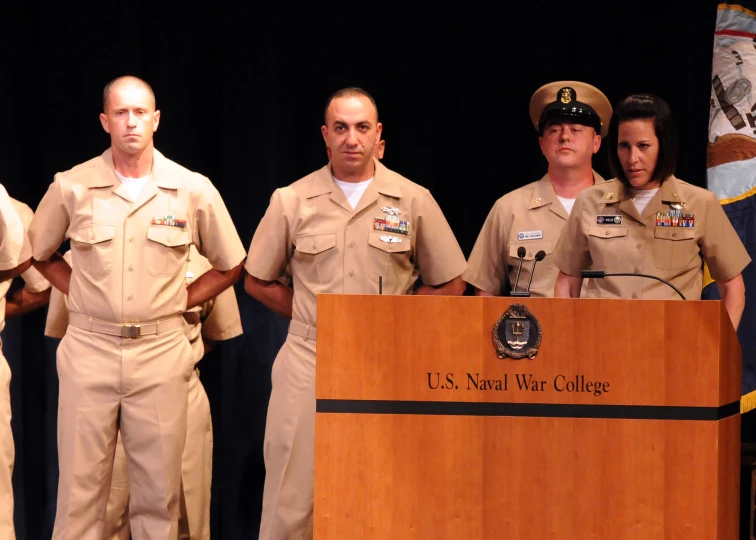 men and women in uniforms standing at a podium