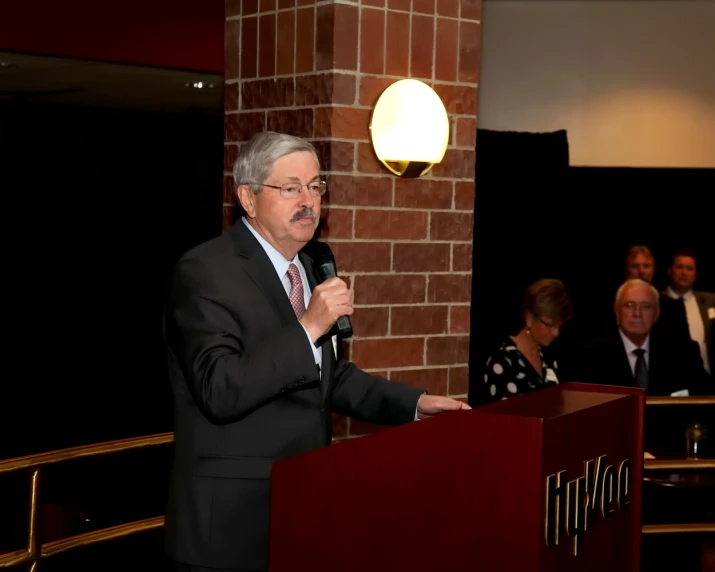 a man in a suit talking into a microphone