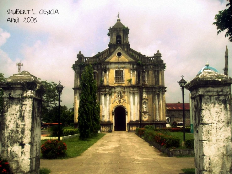 a church on a small road with lots of vines growing around it