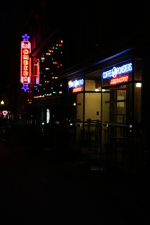 the neon lights are glowing brightly over a restaurant