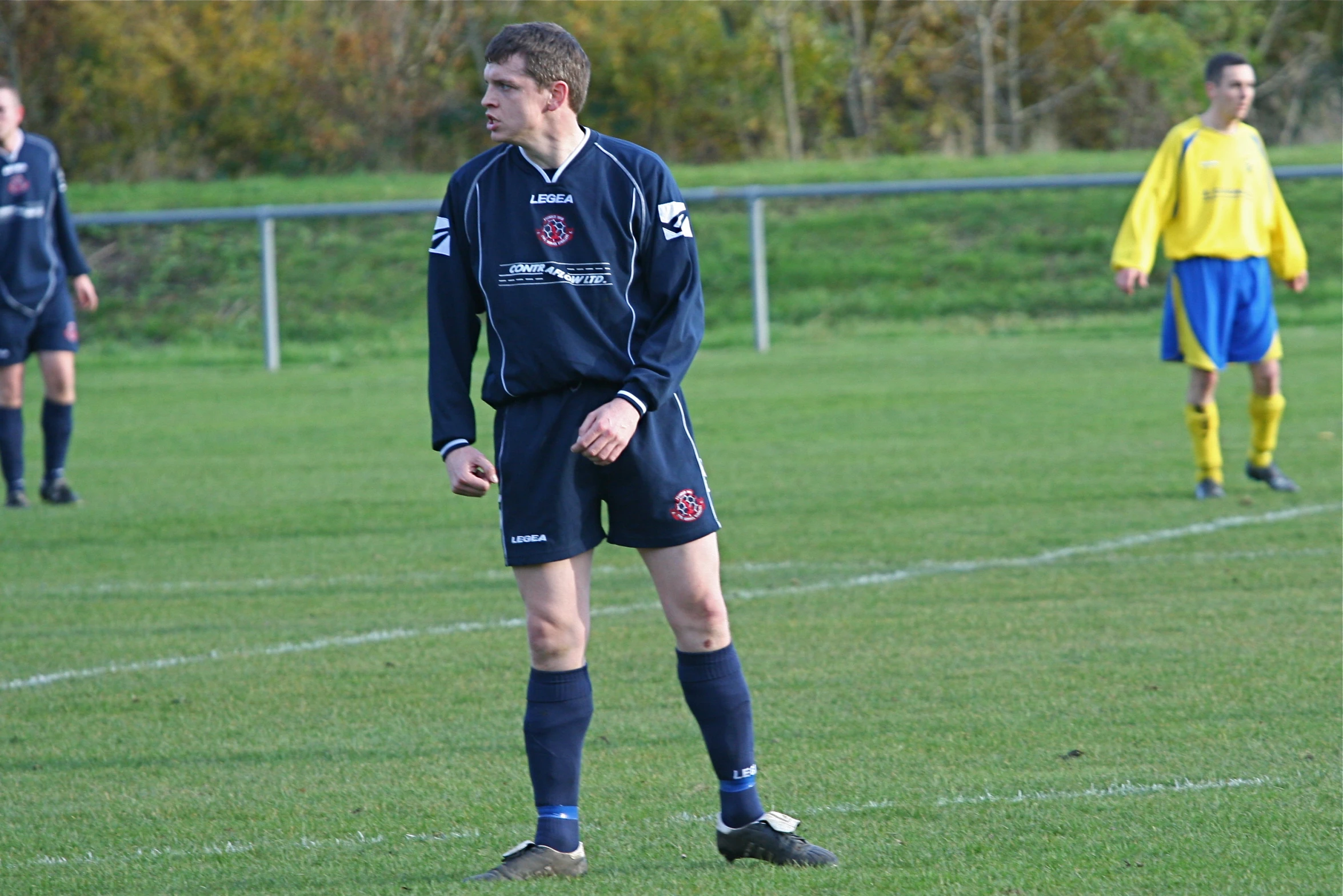 a couple of young men standing on a lush green field