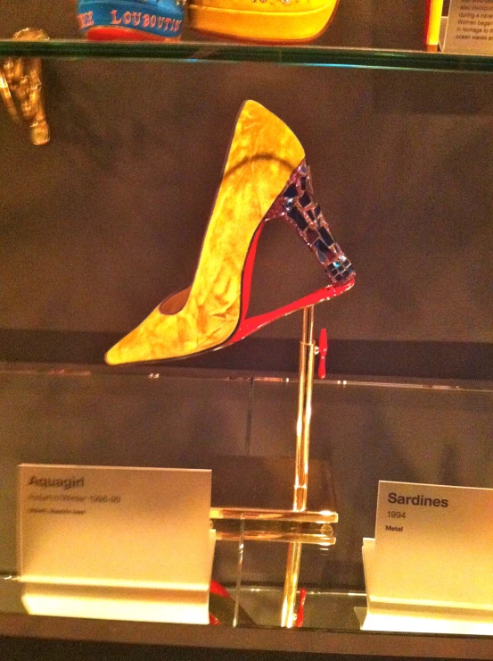 a pair of stiletto shoe on display inside a glass case