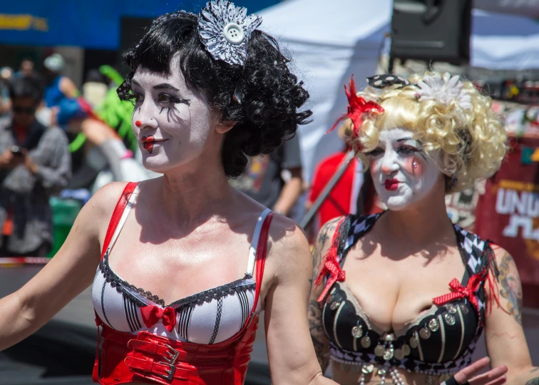 two woman in costumes are walking down the street