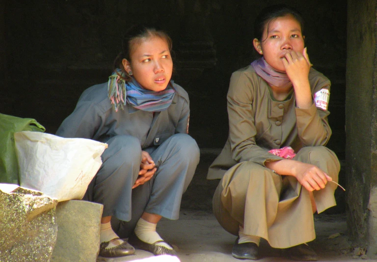 a pair of women sitting next to each other