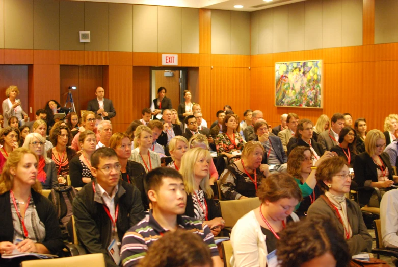 the large crowd has people seated in chairs listening