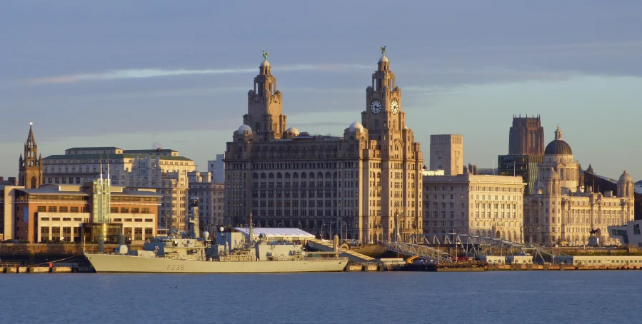 a large military vessel is parked in front of a city