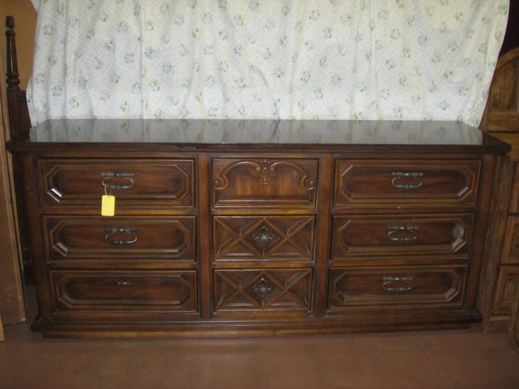 an old wooden dresser with floral valance and fabric top