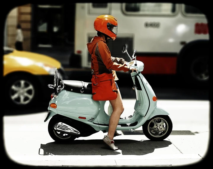 a woman on a moped riding along a street