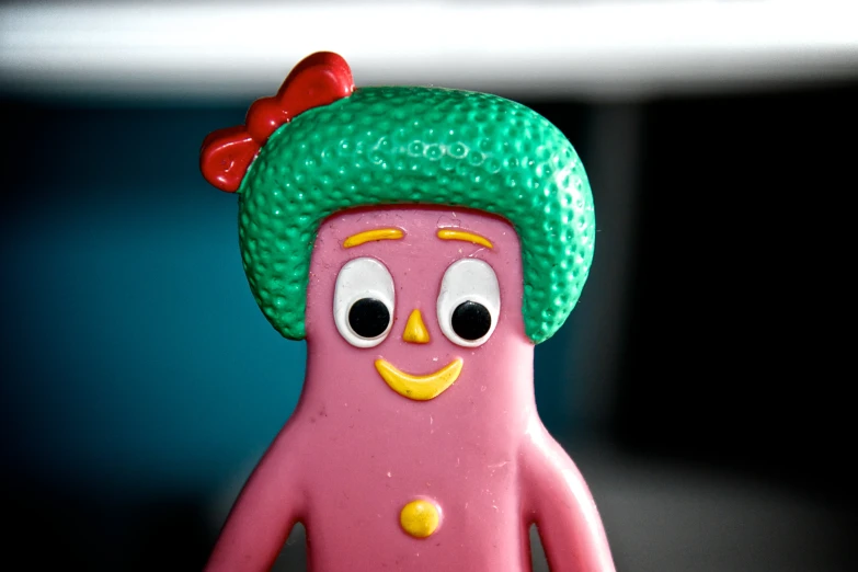 a toy figure in the shape of a doll with a green headband on