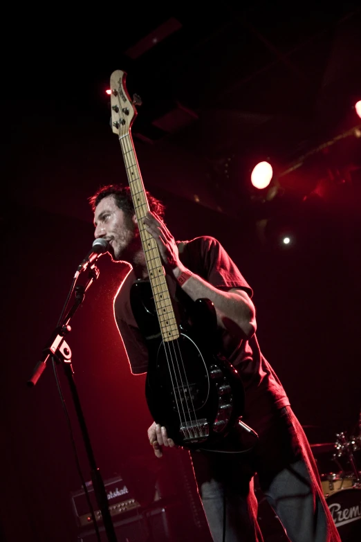 a man holding an electric guitar in front of a microphone