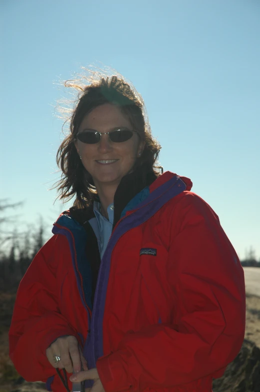 a person that is wearing a red jacket and holding onto a cell phone